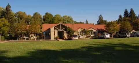 Exterior view of Brookdale Roseville building with red roof, parking lot, and trees.