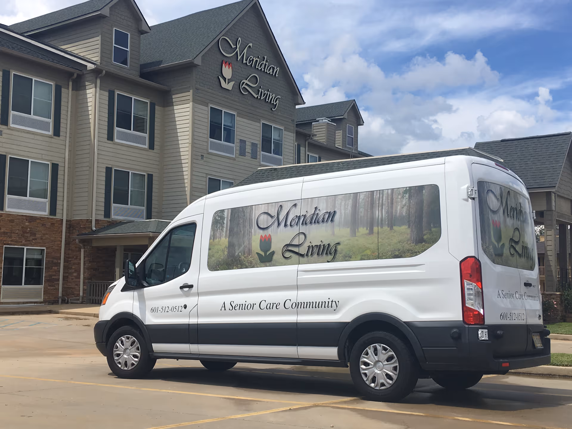 The Meridian Living senior care building with a white Meridian Living shuttle van parked in front.