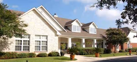 Brookdale Centennial Park exterior shows a cream-brick building with a covered front porch and landscaping.
