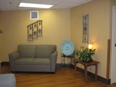 Lounge area in Community Care Center with sofa, plants, and wall decor.