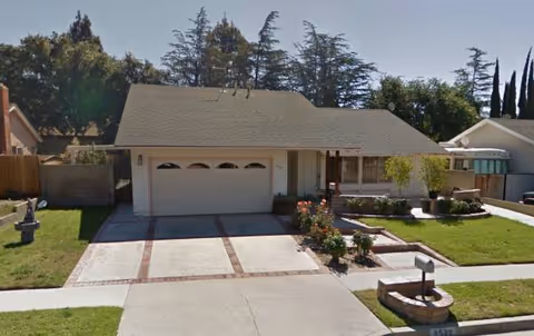 Front view of a single-story senior care home with garage and manicured lawn