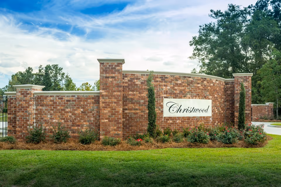 Brick entrance wall with landscaping and a sign that reads "Christwood".