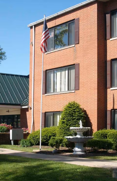 Envive Healthcare of Lawrenceburg exterior: brick building with flagpole, fountain, and manicured landscaping.