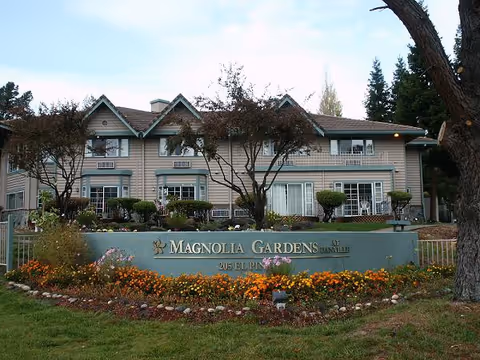 Exterior view of Magnolia Gardens Assisted Living with a landscaped front sign.