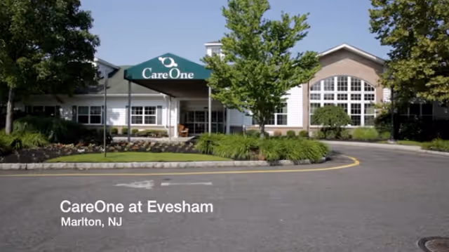CareOne at Evesham exterior building entrance with landscaping and a green awning