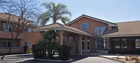 Exterior view of Fresno Senior Living facility with entrance canopy and landscaping.