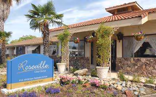 Exterior view of Roseville Care Center with palm trees, hanging baskets, and stone facade.