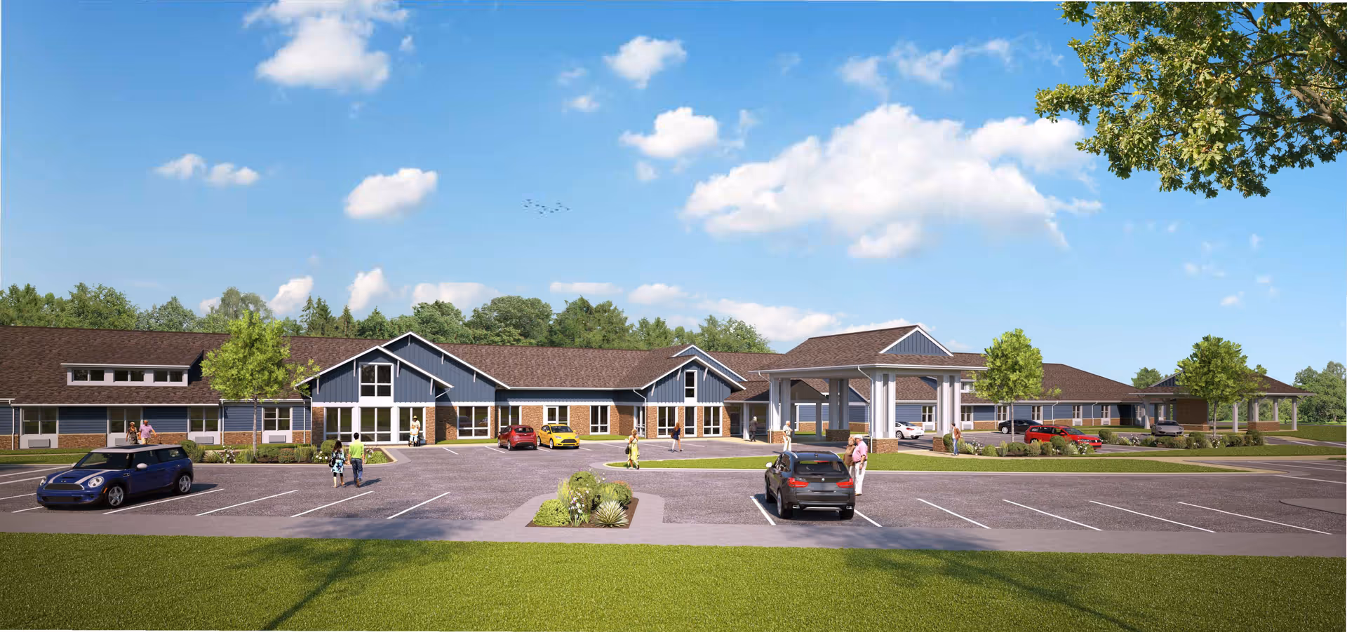 Exterior view of English Meadows Harrisonburg Campus, a single-story senior living facility with blue siding and brick accents. The building has multiple peaked roofs and large windows. Several cars are parked in the parking lot in front, and a few people are walking near the entrance. The sky is blue with scattered clouds, and there are trees and green grass surrounding the area.