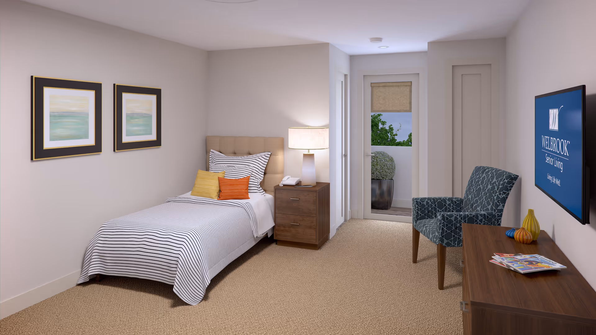 A neatly arranged bedroom in a senior living facility featuring a single bed with striped bedding and colorful pillows, a wooden nightstand with a lamp and phone, two framed paintings on the wall, a patterned armchair, a wooden dresser with magazines and decorative items, and a wall-mounted TV displaying the Welbrook Senior Living logo. A door leads to an outdoor balcony with greenery visible outside.