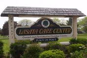 Outdoor Lasata Care Center sign with well-manicured shrubs and greenery.