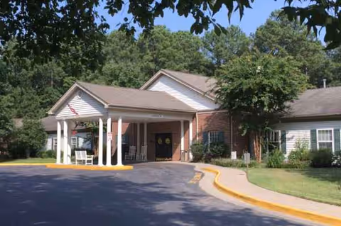 Exterior view of Vista Park Memory Care Center entrance with drive, columns, and landscaping.