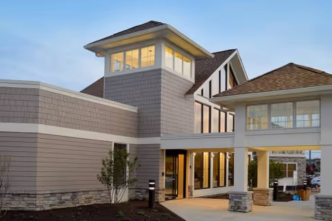 Exterior view of a modern senior living facility with large windows and a welcoming entrance.
