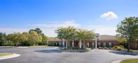 Single-story senior living facility with front entrance and landscaped parking area.