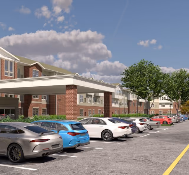 Senior living facility Harmony at Glasgow exterior with parked cars and trees under blue sky