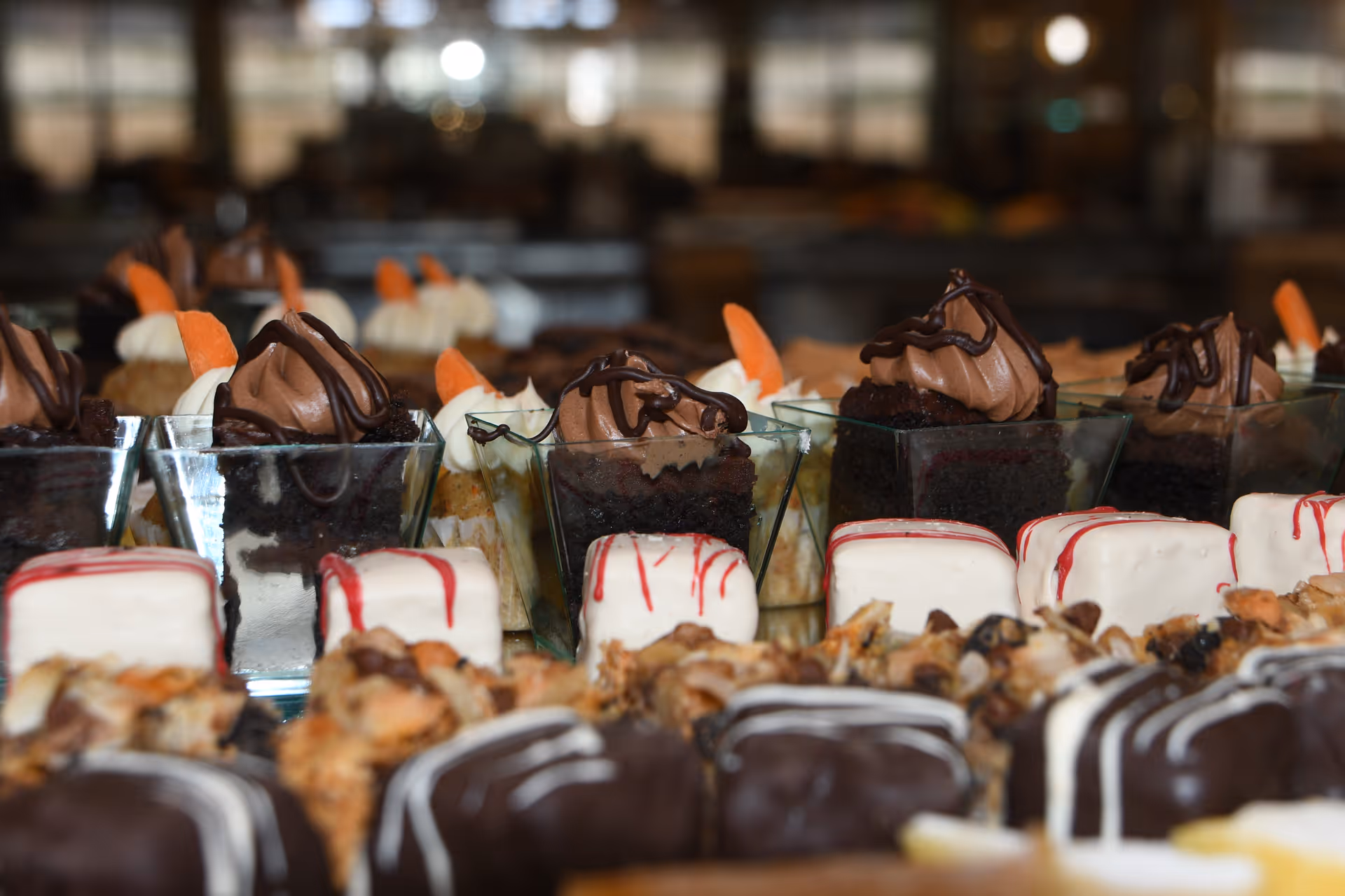 Close-up of an assortment of small chocolate and cream desserts arranged in a display.