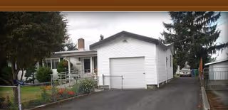 Evergreen Gardens AFH Shattuck: a single-story white building with a garage door.