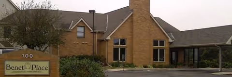 Exterior view of Benet Place facility with brick building and sign.