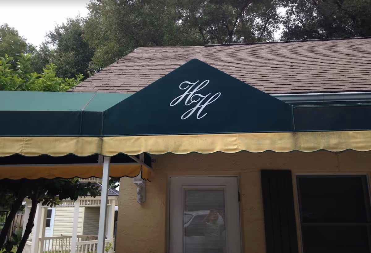 A green awning with yellow trim featuring the initials 'HH' over the entrance of Heidi's Haven.