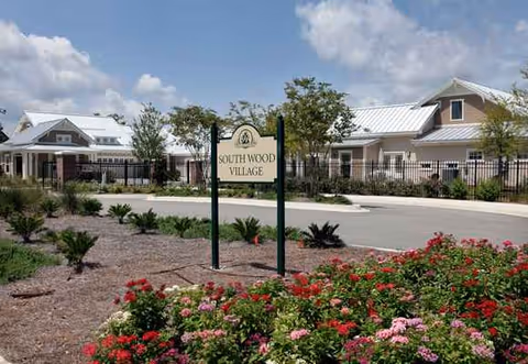 Exterior view of Westminster Woods on Julington Creek with landscaped entrance and sign.
