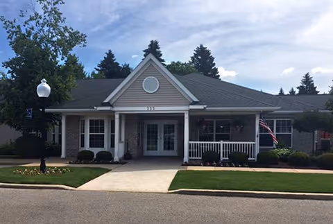 Front view of a single-story senior living facility with a welcoming entrance and lawn.