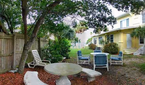Outdoor patio at Edgewater Retirement Manor with blue chairs and a round stone table.