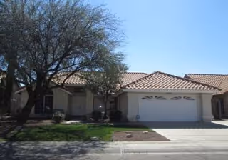 Front exterior of a single-story care home with a two-car garage.