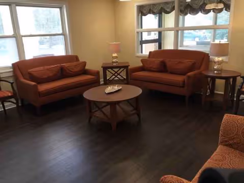Two red-orange sofas face a central coffee table in a cozy living room.