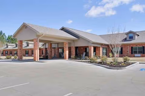 Exterior view of Gulfport Care Center entrance with brick columns and covered driveway.