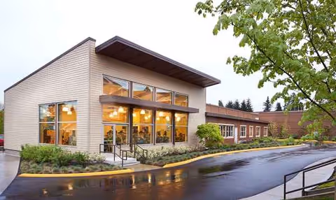 Exterior view of Emerald Heights senior living building with large glass windows and landscaped entrance