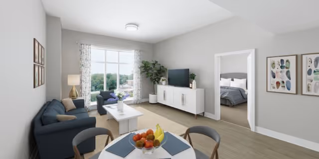 Bright living room with a sofa, coffee table, TV console, dining table, large window with curtains, and a doorway leading to a bedroom.