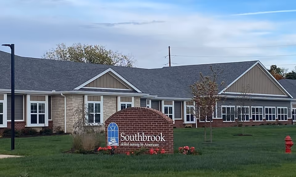Brick sign reading "Southbrook" in front of a single-story senior living building on a grassy lawn.