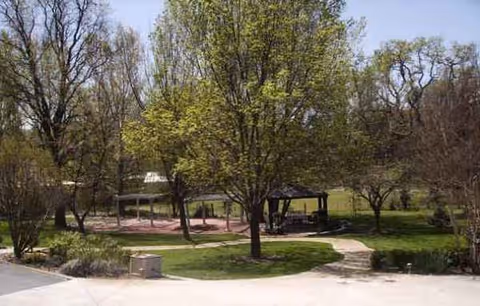 Meadowview Manor outdoor courtyard with trees, gazebos, walkways, and grassy seating areas