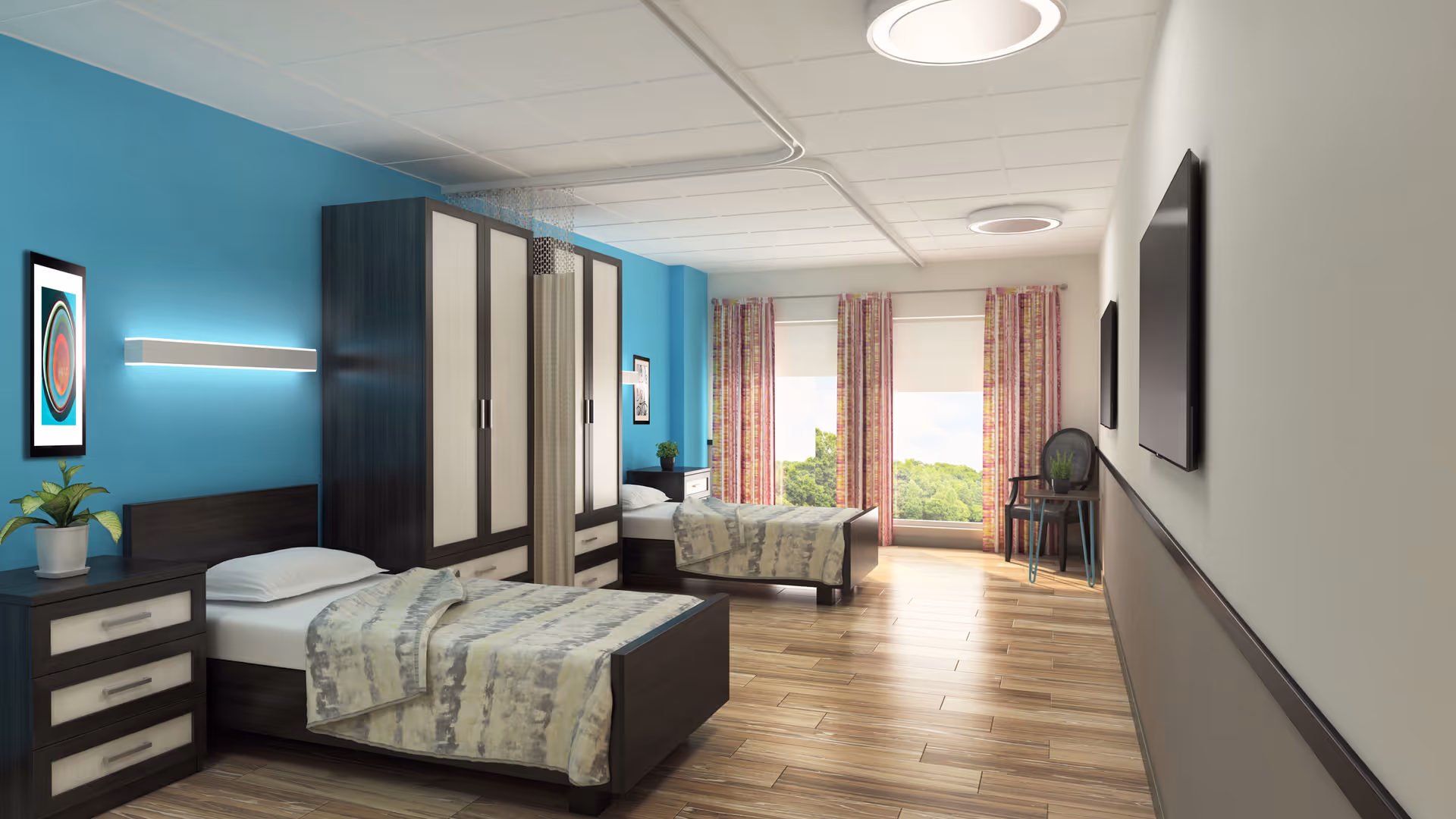 A bright, clean bedroom with two single beds, each with a nightstand and a wardrobe between them. The room has wooden flooring, a blue accent wall with framed artwork, large windows with patterned curtains letting in natural light, and a chair near the window. A flat-screen TV is mounted on the opposite wall.