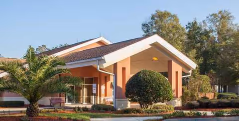 Front entrance of a single-story building with a covered drive and landscaped entry.