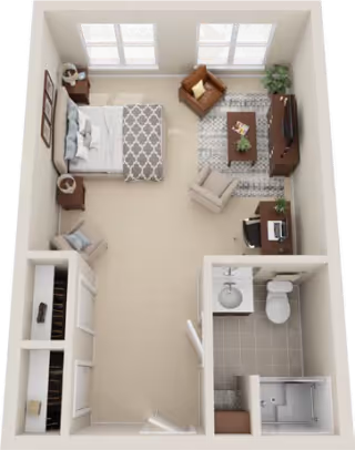 Top-down view of a senior living studio apartment layout featuring a bedroom area with a bed, nightstands, and a chair, a living area with two armchairs, a coffee table, a TV on a stand, and a desk with a computer. The apartment also includes a bathroom with a toilet, sink, and shower, and a closet near the entrance.