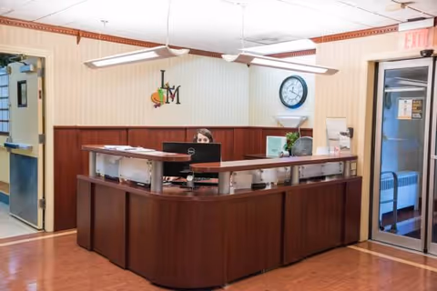 Reception desk in Laurel Manor lobby with staff member at computer.