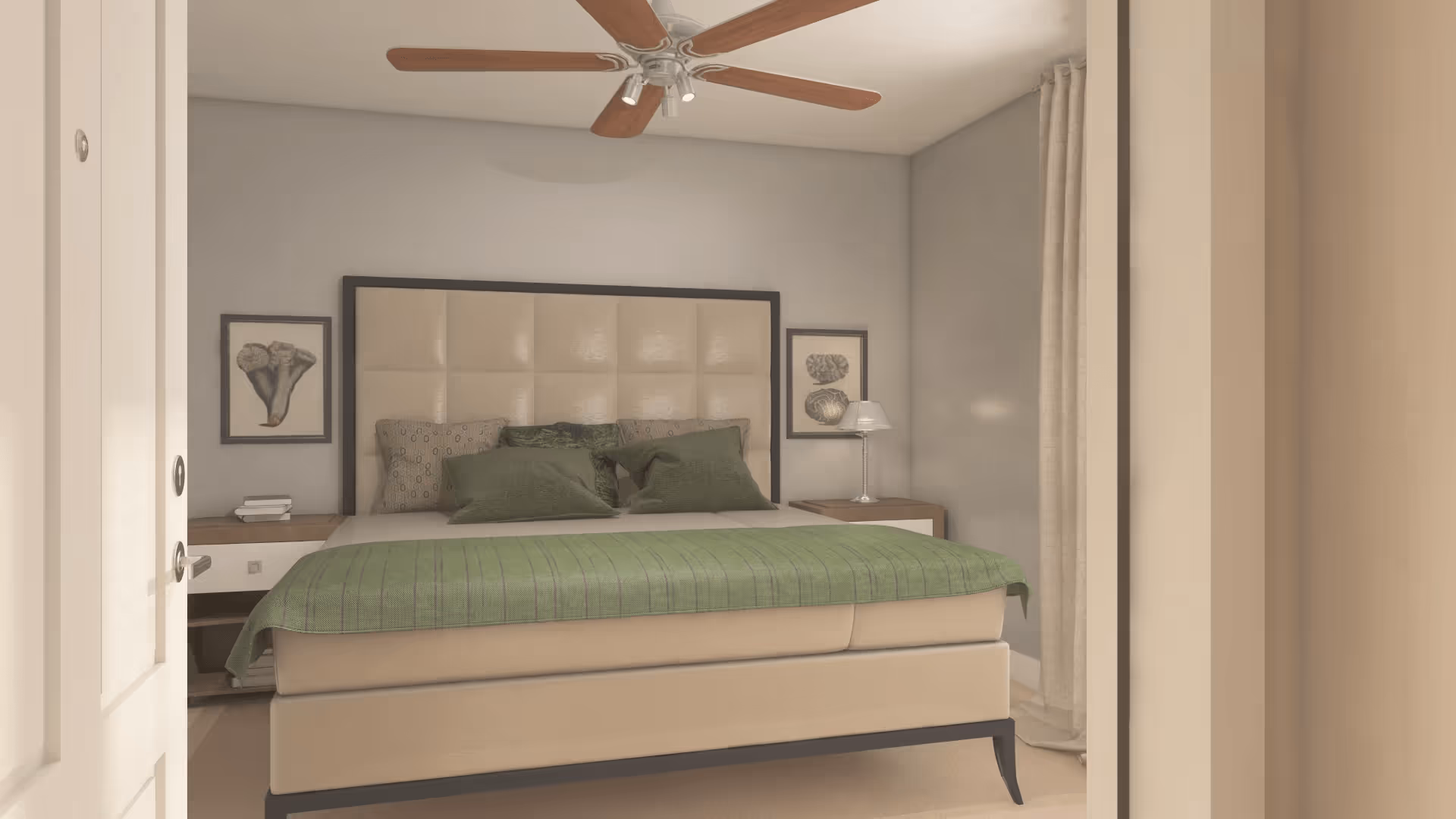 View into a bedroom with a large bed featuring a beige upholstered headboard and green bedding. There are two bedside tables with lamps and framed artwork on the walls. A ceiling fan with wooden blades is mounted on the ceiling, and beige curtains hang by the window.