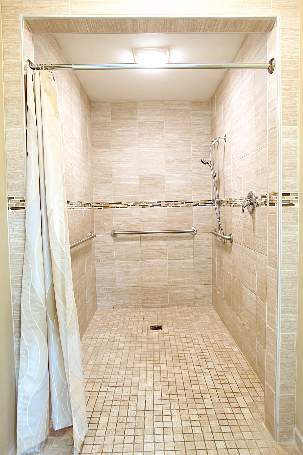 Tiled walk-in shower with a curtain, grab bars, and a handheld showerhead.