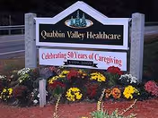 Sign for Quabbin Valley Healthcare with colorful flowers in front
