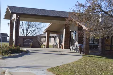 Front entrance of Linn Community Nursing Home with a covered drive and benches.