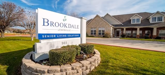 Exterior view of Brookdale Lewisville with a sign and landscaped front yard.