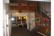 Interior of a senior care lobby with stairs, festive decor, and seating.