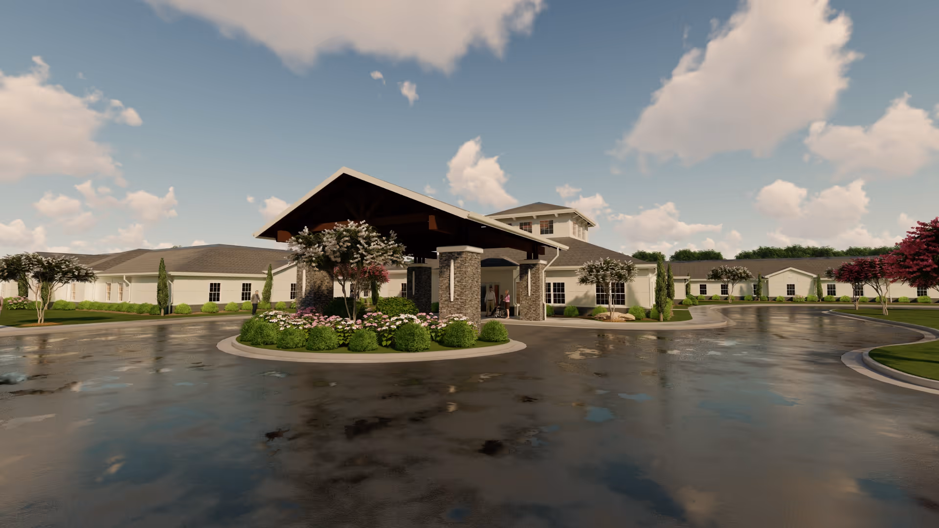 Front entrance of a single-story senior living building with a covered porte-cochere, landscaped circular drive, and wet pavement under a partly cloudy sky.