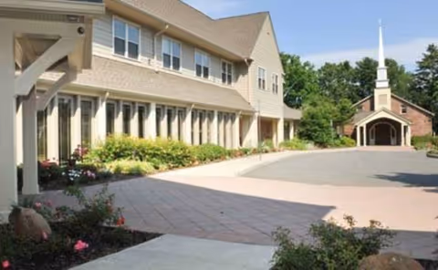Exterior view of The Cliffs at Eagle Rock with a paved courtyard and chapel.