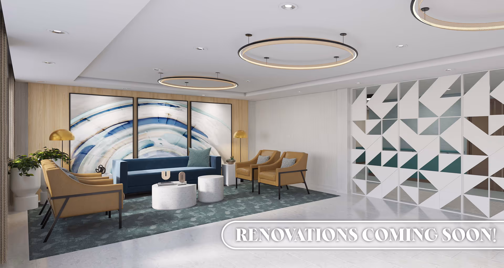 A modern and stylish living room area with a blue sofa, four tan armchairs, two round white coffee tables, and two gold floor lamps. The room features a large abstract triptych artwork on the wall behind the sofa, a patterned area rug, and a decorative geometric partition on the right side. The ceiling has recessed lighting and two circular pendant lights. Text at the bottom right corner reads 'RENOVATIONS COMING SOON!'