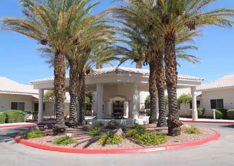 Front exterior of The Homestead at Boulder City with palm trees and a circular driveway.