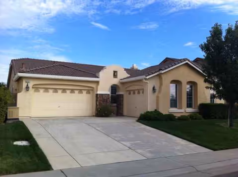 Front view of a beige stucco senior living facility with a two-car garage.