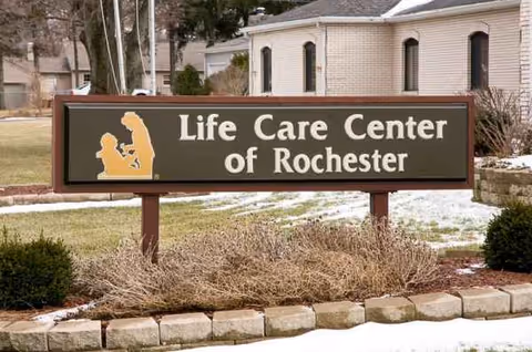 Outdoor sign for Life Care Center of Rochester with a brick building in background