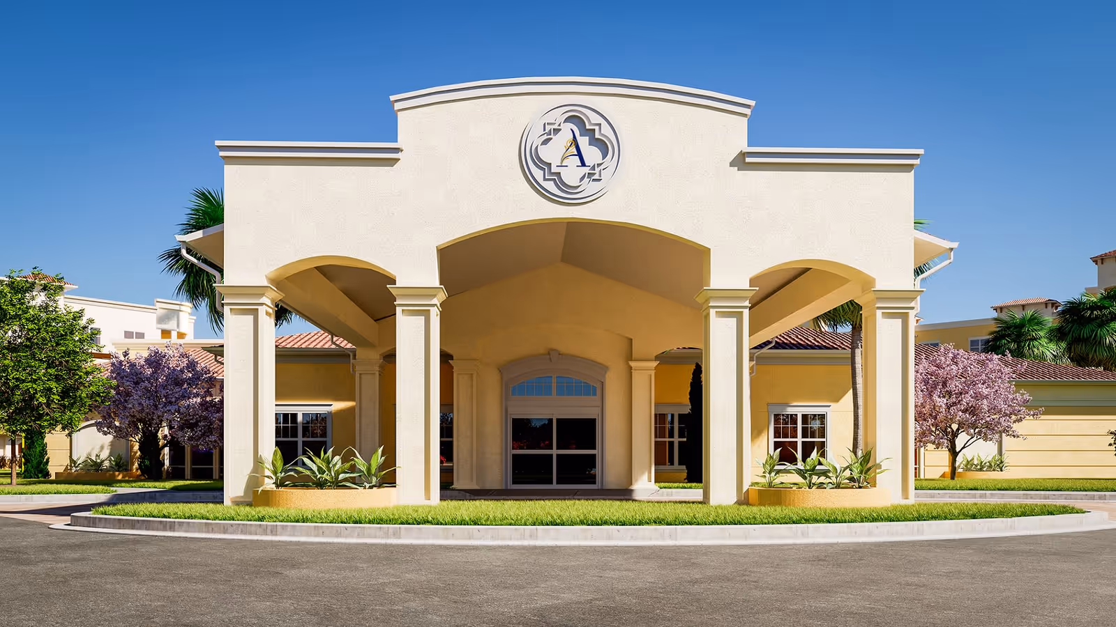 Front exterior view of The Alloro at University Groves building with a covered entrance supported by columns, landscaped greenery, and clear blue sky.