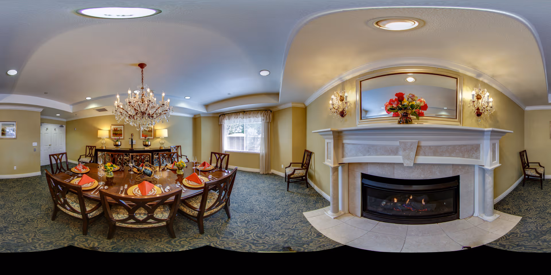 Well-appointed dining room with a large round table set for a meal, a chandelier overhead, and a fireplace on one wall.